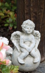 Trauriger kleiner Engel sitzt auf einem Grab