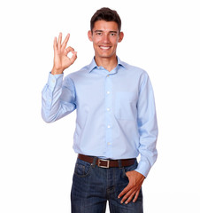 Smiling man standing with an ok finger sign.