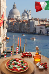 Obraz premium Classic Italian pizza in Venice against canal, Italy