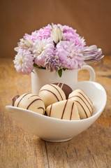 Beautiful aster flower bouquet and chocolates on wooden table