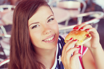 Stylish young woman eating at a cafe