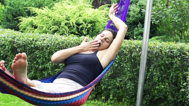 Sleepy woman swinging in a hammock, slow motion shot at 240fps