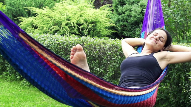 Sleepy woman swinging in a hammock, slow motion shot at 240fps