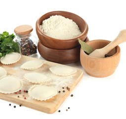 Raw dumplings and ingredients on wooden desk, isolated on white