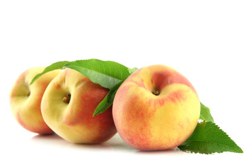 Ripe sweet peaches with leaves, isolated on white