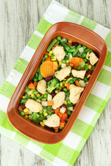 Casserole with vegetables and meat, on wooden background