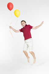 Fototapeta na wymiar Happy boy is jumping with balloons