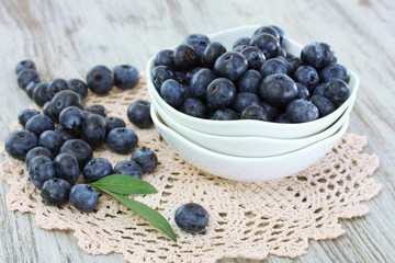 Blueberries in plates on napkin on wooden background