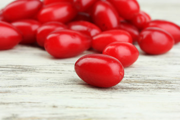 Fresh cornel berries on wooden background