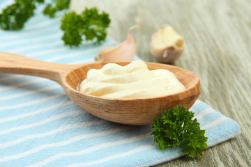 Sour cream in spoon on table close-up