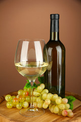Composition of wine bottle, glass of white wine, grape