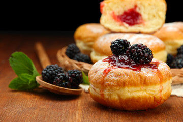 Tasty donuts with berries on wooden table