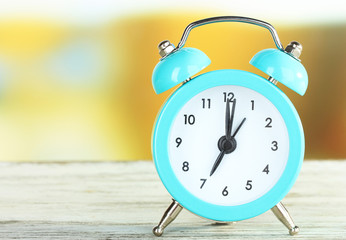 Alarm clock on table on bright background