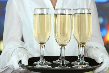 Waitresses holding tray with glasses of champagne