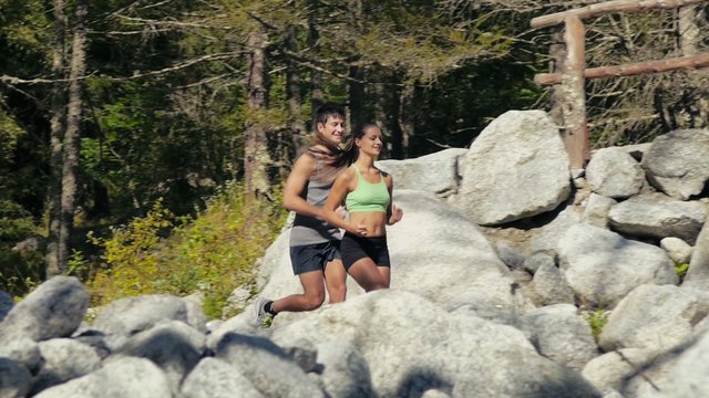 2of4 Young man and woman running on mountain trail, sport