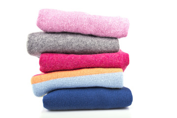 A stack of colored, woolen jumpers