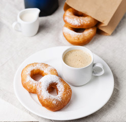 Donuts and coffee on morning breakfast table