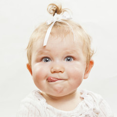 Portrait of an adorable baby girl with tongue sticking out © Tommaso Lizzul