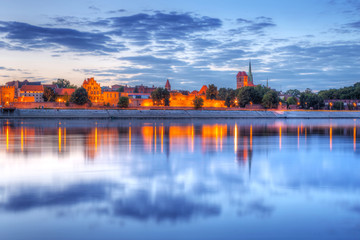 Torun old town reflected in Vistula river at sunset, Poland - obrazy, fototapety, plakaty