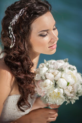 Bride at wedding day with makeup and hairstyle, holding bouquet