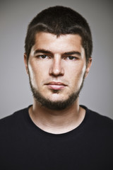 Portrait of a real smiling man over grey background.