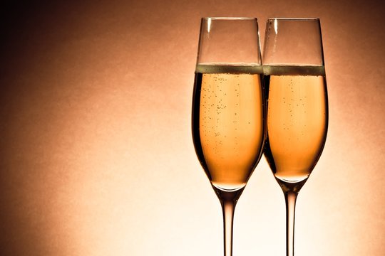 two glasses of champagne with golden bubbles and space for text