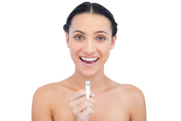 Enthusiastic young brunette holding nail clippers