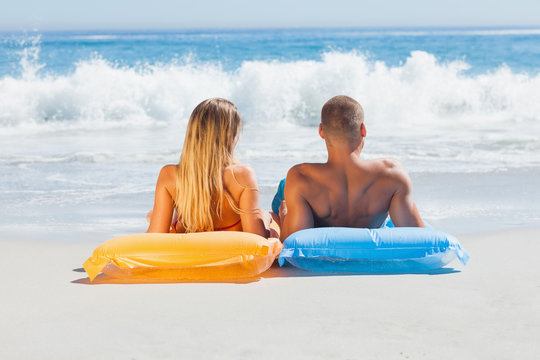 Cute couple in swimsuit sunbathing together
