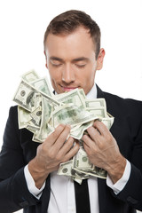 Smelling money. Happy young businessman in formalwear smelling m