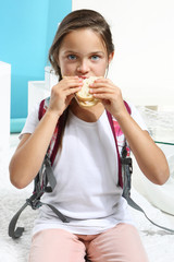dziewczynka je kanapkę przed wyjściem do szkoły