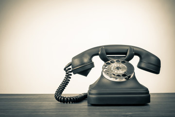 Retro rotary telephone on table for vintage background