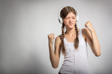 Young woman with headphones listening music and dancing.