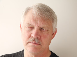 older man has a distrusting look