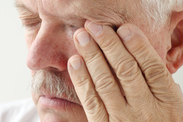 senior man has eyestrain and fatigue