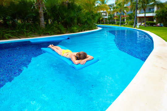 Woman in swimming pool at caribbean resort.