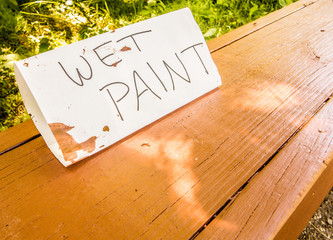Hand made wet paint sign on a wooden park bench