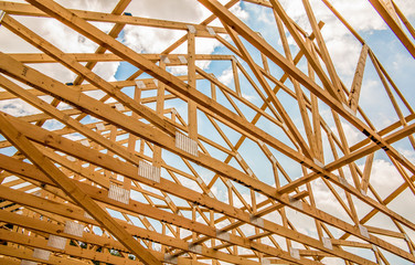 Wood house truss against blue sky with puffy clouds - obrazy, fototapety, plakaty
