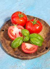 tomato with leaf of basil on a wooden shabby blue background