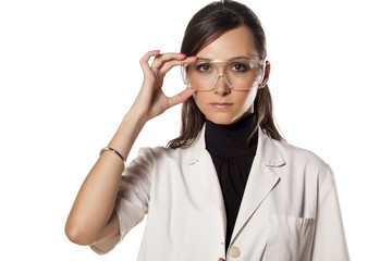 serious woman lab technician holds her goggles