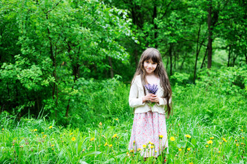 Fototapeta na wymiar Elegant child girl posing with bunch of flowers