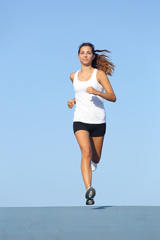 Front view of a beautiful sportswoman running towards camera