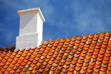 old tiles red roof with himney sky background