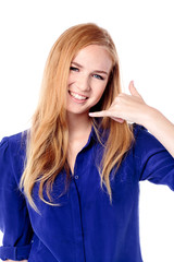 Smiling young woman making a call me gesture