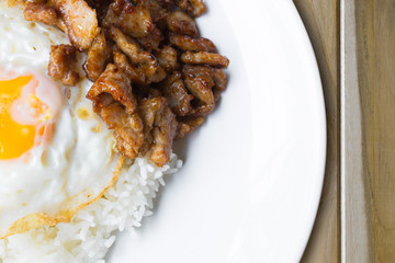 fried pork with pepper and garlic serve with fried egg and cooke