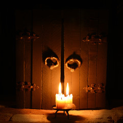 Three burning candles on the closed door background