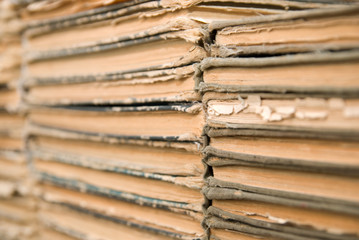 A lot of old, worn books are lying on top of each other.