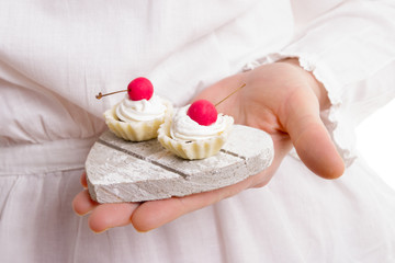 Woman is holding a cherry cookies on wooden plate