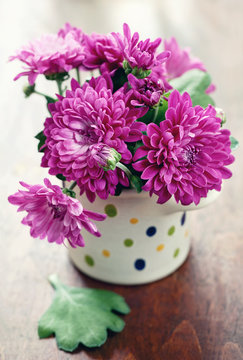 purple chrysanthemum flowers in a flower vase on a table.