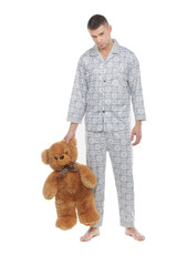 Man with teddy bear. Young man in pajamas holding teddy bear and