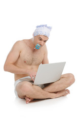 Big baby. Infant adult man in diaper working at the computer whi
